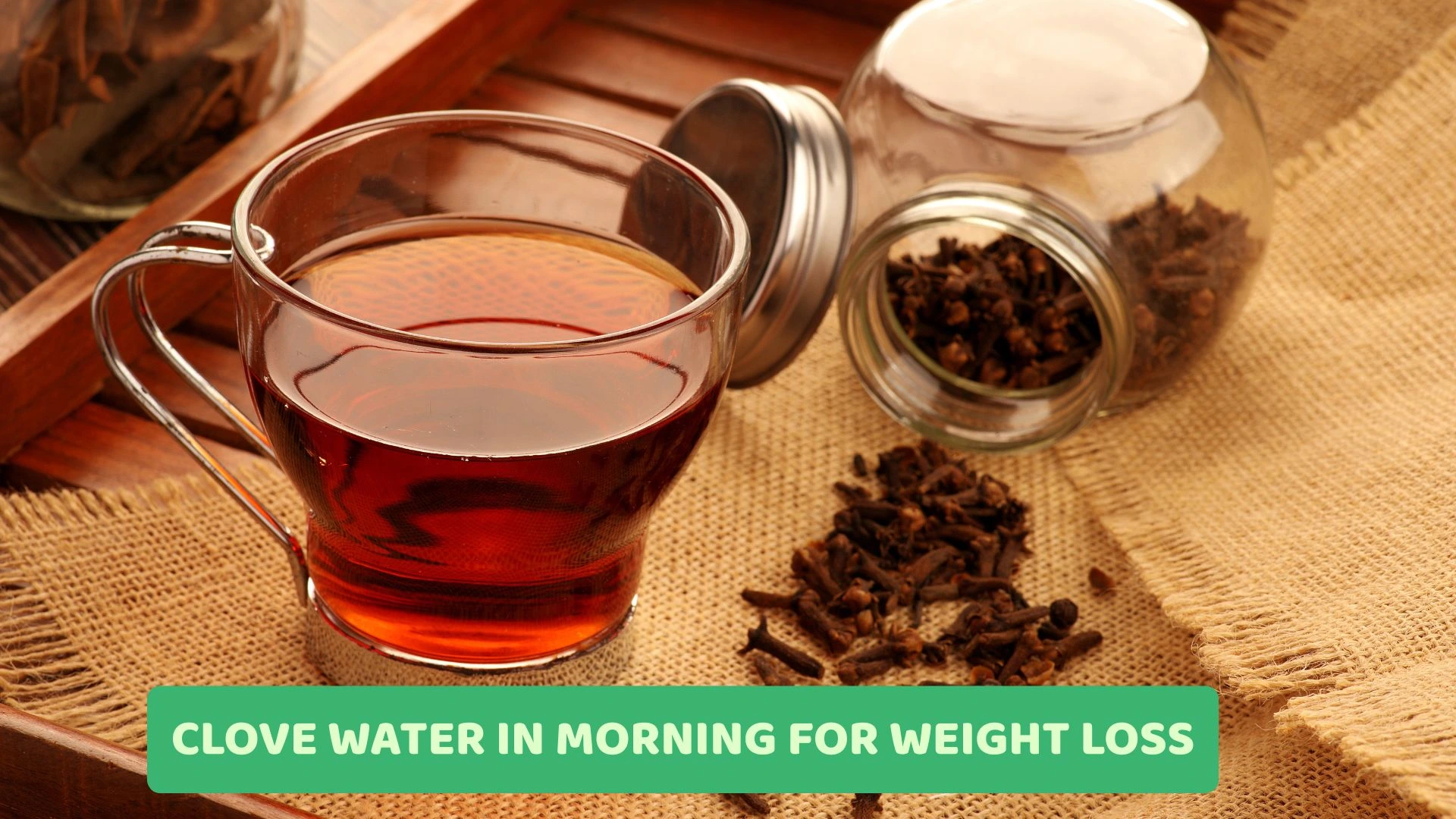 A glass of clove water with cloves beside it, symbolizing its morning health benefits for weight loss and metabolism boost.